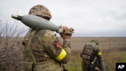 Tentara Garda Nasional Ukraina bersiap menembaki Rusia dengan mortir di dekat Kharkiv, Ukraina, Selasa, 25 Oktober 2022. (Foto: AP/Andrii Marienko)