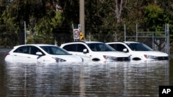 Tiga mobil terjebak banjir di Shepparton, Australia, Senin, 17 Oktober 2022. (Diego Fedele/AAP via AP)