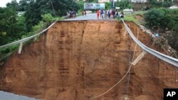 Watu wakishuhudia daraja lililosomwa na maji kutokana na mafuriko huko KwaZulu-Natal nchini Afrika kusini