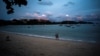 FILE - Tourists walk at a beach in Phuket, Thailand, April 4, 2022. Picture taken April 4, 2022. REUTERS/Athit Perawongmetha
