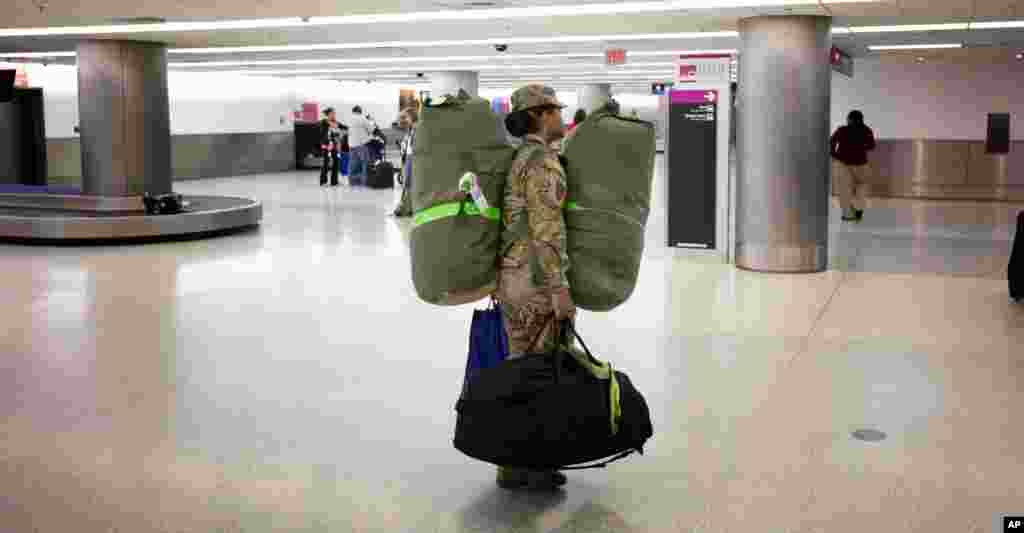 Tentara Angkatan Darat AS Sersan Angelica Ciriaco bersiap pulang ke rumah dari Bandar Udara Internasional Miami setelah bertugas 10 bulan di Afghanistan (26/11). (AP/J. Pat Carter)