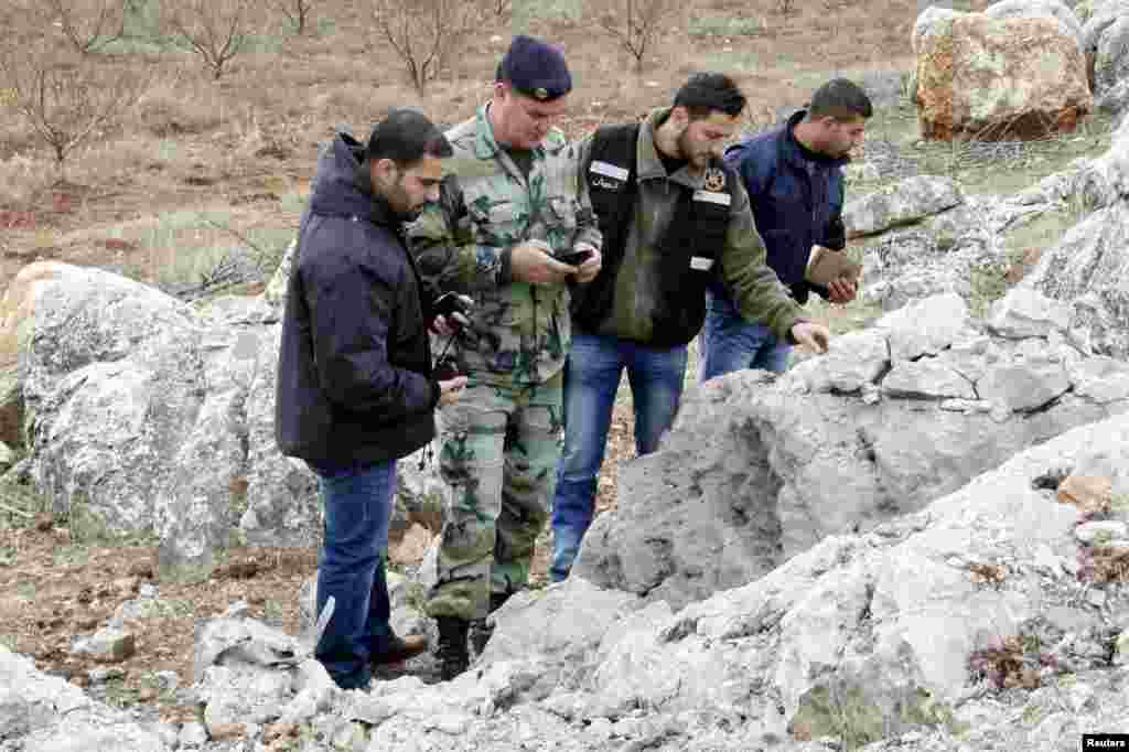Lebanese army personnel inspect the remains of a shell that was launched from Lebanon to Israel. According to activists, the shell landed about 500m from the Lebanese-Israeli border, Sarada, Lebanon, Dec. 29, 2013. 