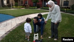 Warga Suriah dengan status imigrasi, Temporary Protected Status (TPS), Mohammad Alala dan istrinya, keduanya dari Suriah serta dua anak mereka yang lahir di AS, Taim dan Amr bermain di taman dekat rumah mereka di Miramar, Florida, 24 Januari 2018. 