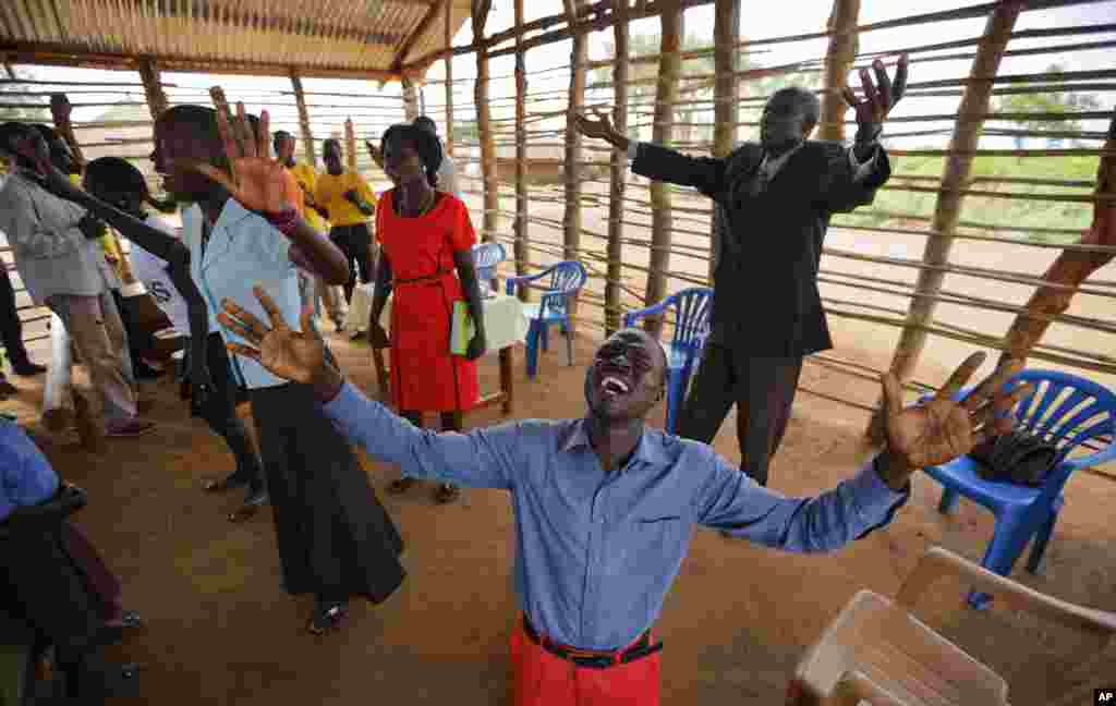 Preacher Daniel Rasash falls to his knees and weeps in prayer, at the Yoyo Pentecostal Church in Bidi Bidi refugee settlement in northern Uganda.