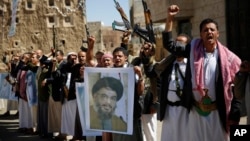 FILE - Shi'ite rebels, known as Houthis, hold a poster of Hezbollah leader Sheikh Hassan Nasrallah during a rally in support of Iranian-backed Hezbollah, in Sana'a, Yemen, March 3, 2016.