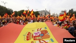 Demonstran mengibarkan bendera Spanyol untuk mendukung Spanyol bersatu di Madrid satu hari sebelum referendum kemerdekaan yang dilarang berlangsung di Catalonia pada 1 Oktober 2017.