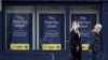People wearing face masks walk past a closed retail unit in Preston, Britain, March 9, 2021. Europeans are hopeful that U.S. President Joe Biden's stimulus package will benefit their struggling economies, too. 