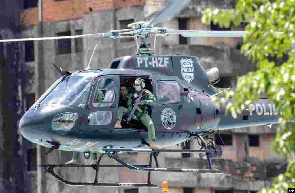 លោក Marcelo Pinheiro ឬ «Piloto» មេដឹកនាំនៃក្រុមឧក្រិដ្ឋជនប្រេស៊ីល Comando Vermelho, (ស្តាំទីពីរ) ត្រូវបានគេនាំតាមឧទ្ធម្ភាគចក្រប៉ូលិសរដ្ឋ Parana បន្ទាប់ពីចាកចេញពីទីក្រុង Foz do Iguacu កាលពីថ្ងៃទី១៩ ខែវិច្ឆិកា ឆ្នាំ ២០១៨។