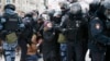 Seorang polisi menahan seorang pria, sedang rekannya menyetop seorang perempuan (tengah), saat demo menentang penahanan pemimpin oposisi Rusia, Alexei Navalny, di Moscow, Rusia, 23 Januari 2021.