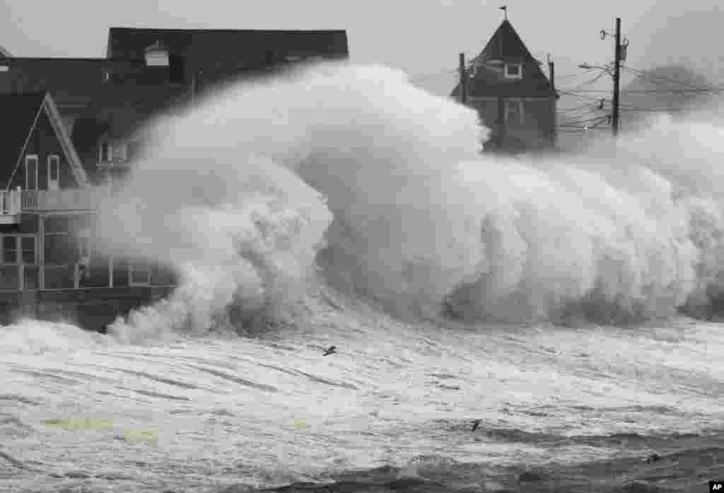 Waves crash into a seawall and buildings along the coast in Hull, Massachusetts, November 7, 2012.