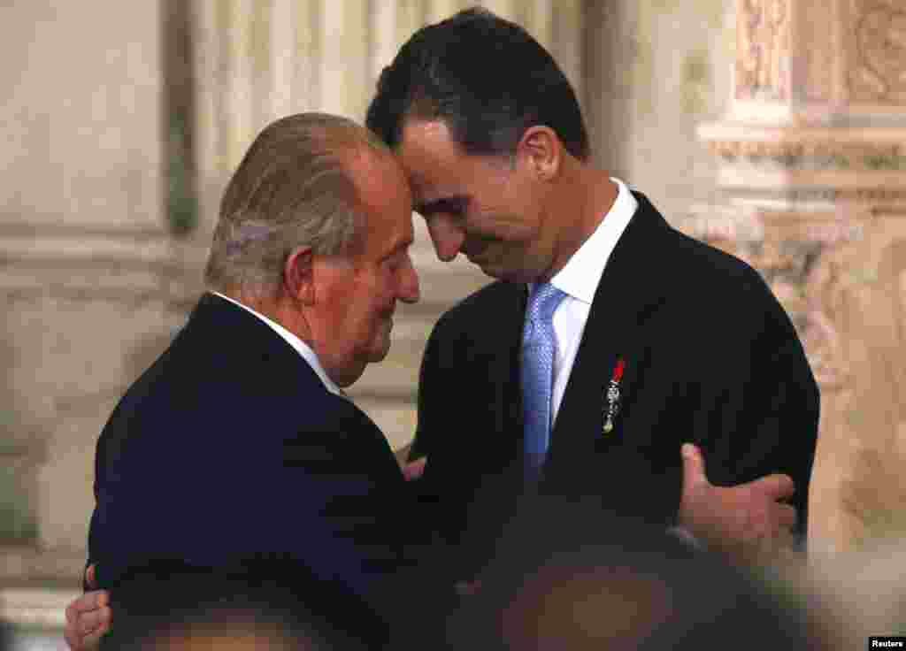 Spain's King Juan Carlos and his son Crown Prince Felipe (R) hug each other as they attend the signature ceremony of the act of abdication at the Royal Palace in Madrid.