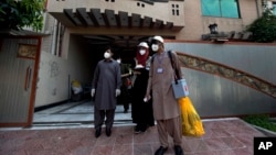 Petugas medis Pakistan melakukan tes virus Corona terhadap warga dari rumah ke rumah. 