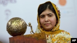 FILE- In this Sept. 6, 2013, image, Malala Yousafzai, who was shot and injured by the Taliban for advocating for girls' education, poses for photographers after being awarded the International Children's Peace Prize 2013.