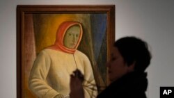 Una mujer toma fotos del cuadro 'Retrato de Ovsana Pavlenko', del artista ucraniano Vasyl Sedliar, durante la inauguración de la muestra de arte ucraniano en el museo Thyssen-Bornemisza en Madrid, el 28 de noviembre de 2022.
