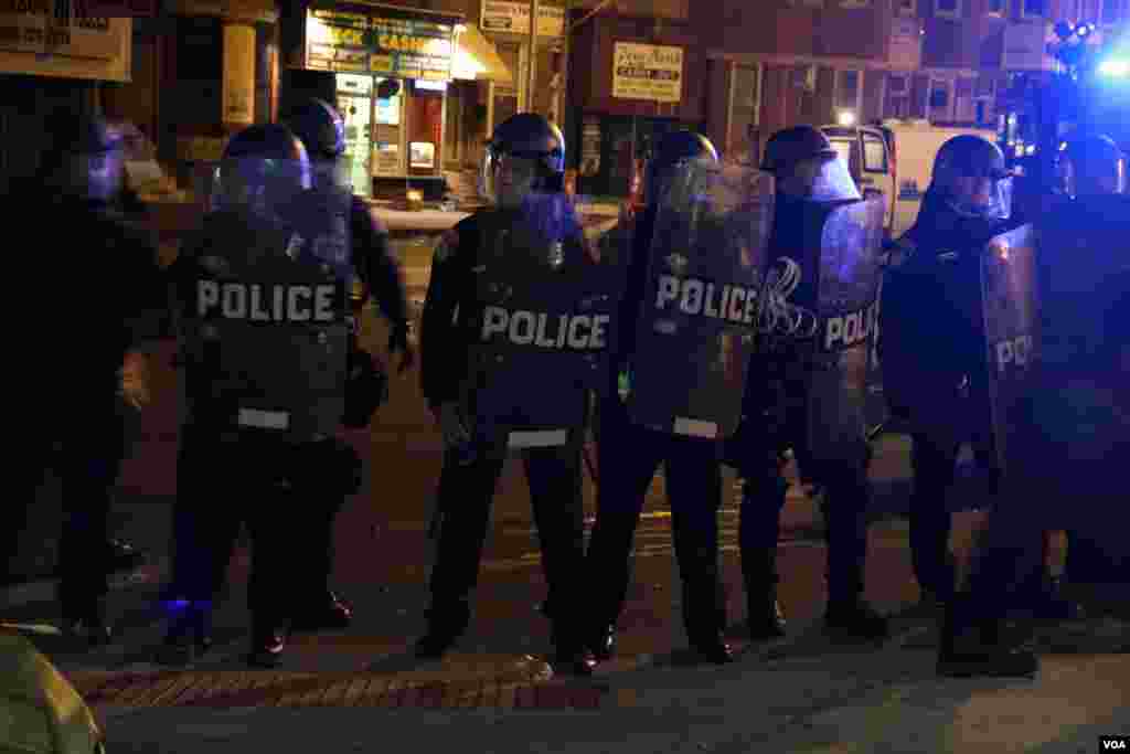 Polisi anti-huru-hara membentuk barisan untuk mendorong demonstran dan media mundur di Baltimore (28/4). (VOA/Victoria Macchi)