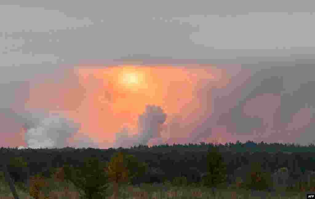 A fire ball is seen in the sky from the village Zaudaika, some 8 km from the epicenter of a serie of explosions at an ammunition depot in Ukraine’s northern Chernihiv region, north of Ukraine. Some 12,000 people were evacuated after ammunition began exploding and set off a huge fire, authorities said.