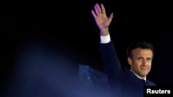 Presiden Prancis Emmanuel Macron melambaikan tangan kepada para pendukungnya dalam perayaan kemenangan dirinya dalam pemilihan presiden Prancis 2022 di Champ de Mars di Paris, Prancis, pada 24 April 2022. (Foto: Reuters/Christian Hartmann)