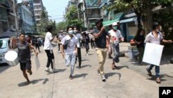 Pengunjuk rasa anti-kudeta lari untuk menghindari pasukan militer dalam aksi protes di Yangon, Myanmar, Rabu, 31 Maret 2021. (AP Photo)