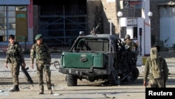 Afghan National Army (ANA) soldiers stand at the site of a blast in Jalalabad city, November 10, 2014.