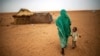 File photo released by the United Nations African Union Mission in Darfur (UNAMID), a woman holds hands with her daughter as they walk at the Zam Zam refugee camp for internally displaced people (IDP) in North Darfur, Sudan. 