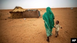 ARSIP – Foto yang dirilis oleh United Nations African Union Mission in Darfur (UNAMID) menunjukkan gambar seorang wanita yang bergandengan tangan dengan anak perempuannya sambil berjalan di kamp pengungsi Zam Zam untuk mereka yang tersingkir di Darfur Utara, Sudan. (foto: AP Photo/UNAMID, Albert Gonzalez Farran)
