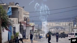 Warga Palestina lari dari gas air mata yang ditembakkan oleh pasukan Israel yang menyerbu kamp Aqbat Jabr, barat daya kota Jericho, 4 Februari 2023.
