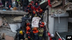 Los rescatistas turcos llevan a Ergin Guzeloglan, de 36 años, a una ambulancia después de sacarlo de un edificio derrumbado cinco días después de un terremoto en Hatay, en el sur de Turquía, la madrugada del sábado 11 de febrero de 2023.