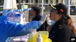 Petugas medis melakukan tes swab di tengah perebakan COVID-19 di Shanghai, China (4/4). 