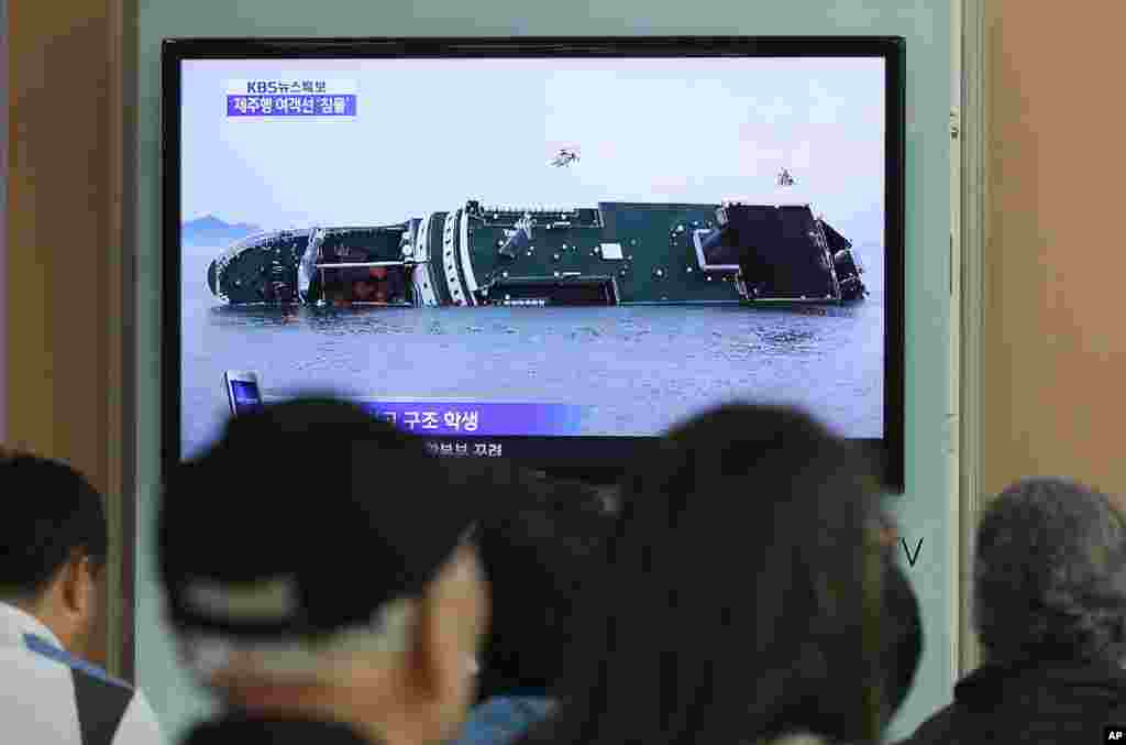 People watch a TV news program showing the sinking ferry, at Seoul Railway Station in Seoul, South Korea, April 16, 2014.