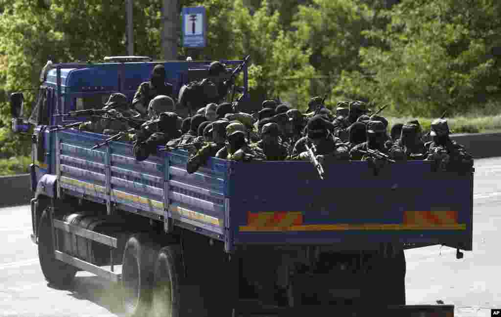 Pro-Russian militia men arrive to take positions outside an airport in Donetsk, Ukraine, May 26, 2014.