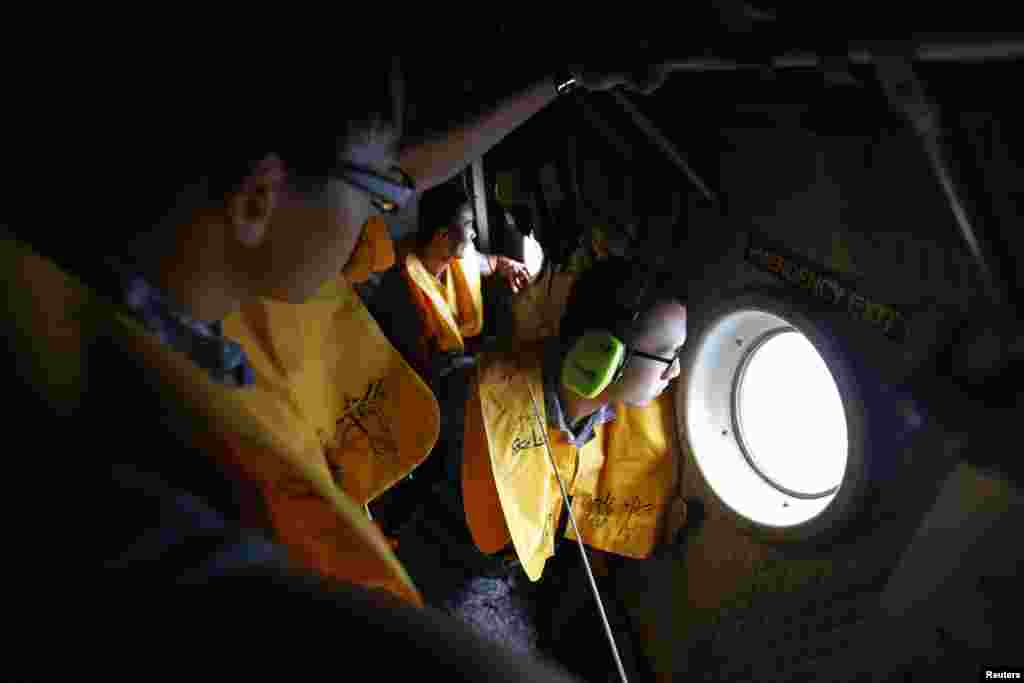 Republic of Singapore Air Force personnel survey the waters during a search and locate operation for the missing AirAsia flight QZ8501 plane at an undisclosed search area, Dec. 30, 2014.