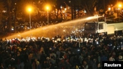 Police use water cannons to disperse demonstrators as they protest against a trade pact with mainland China, near Taiwan's government headquarters in Taipei, early morning, March 24, 2014.