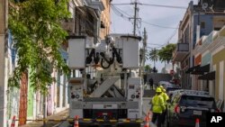 Trabajadores de electricidad realizan reparaciones en la comunidad de Puerta de Tierra tras el paso de la tormenta tropical Ernesto en San Juan, Puerto Rico, el jueves 15 de agosto de 2024. 