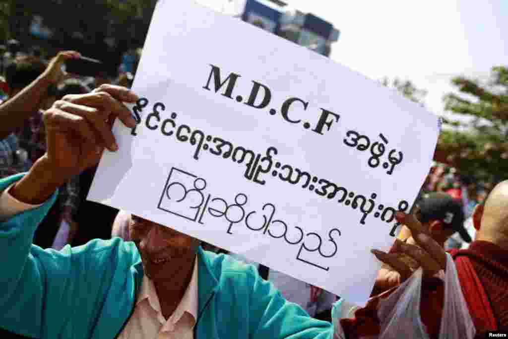A man holds a sign as he waits for political prisoners to be released from Insein prison in Rangoon, Burma, Dec. 31, 2013. 
