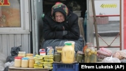 An elderly Ukrainian woman sells home made products in downtown Kiev, Ukraine, on Wednesday, Feb. 3, 2016.