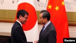 王毅（右）2018年1月28日會見到訪的日本外相河野太郎（路透社）