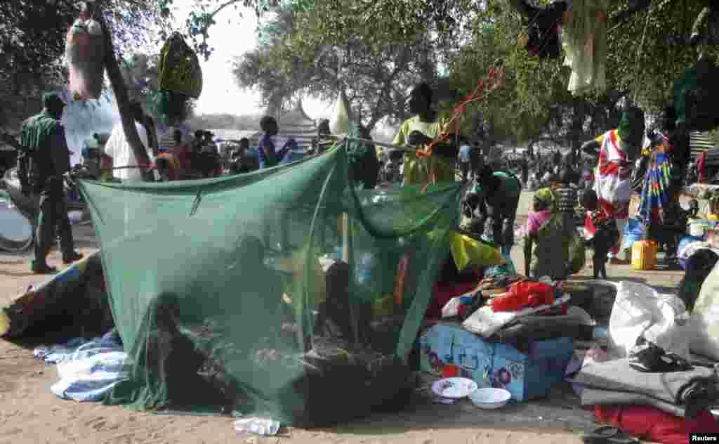 Displaced people gather inside a mosquito net tent as they flee from the fighting between the South Sudanese army and rebels in Bor town, in Juba, South Sudan, Dec. 30, 2013.