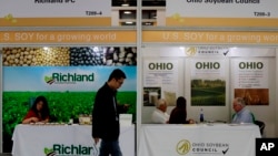 在上海举行的国际大豆展览上，参观者走过美国大豆公司的展台。