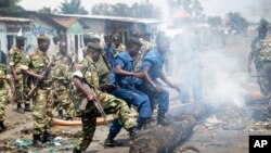 Des miliaires et policiers burundais dégagent d'une voie publique des barricades érigées par des manifestants opposés à un troisième mandat du président Pierre Nkurunziza