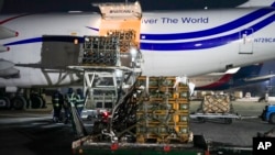 Workers unload a shipment of military aid delivered as part of the United States of America's security assistance to Ukraine, at the Boryspil airport, outside Kyiv, Ukraine, Jan. 25, 2022.