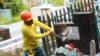 Un operario destruye la placa en una lápida que identifica al difunto como miembro de la Mara Salvatrucha en el cementerio de Santa Tecla, El Salvador, el 1 de noviembre de 2022.