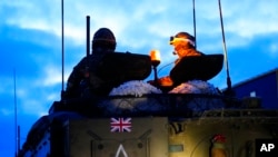 Oficiales militares británicos se sientan encima de un vehículo blindado en el Campamento Militar de Tapa, en Estonia, el 19 de enero de 2023.
