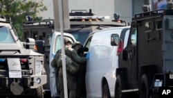 Anggota kepolisian tampak memasuki dan memeriksa sebuah van yang berada di Torrance, California, pada 22 Januari 2023, di mana van tersebut diyakini memiliki kaitan dengan penembakan massal yang terjadi di California pada 21 Januari 2023. (Foto: AP/Damian Dovarganes)