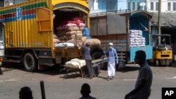 FILE - Sri Lankan traders load a truck with imported commodities during COVID-related travel restrictions in Colombo, Sri Lanka, June 16, 2021. Sri Lanka has cut back on some imports as its foreign exchange reserves dwindle, hindering its ability to repay a mountain of debt.