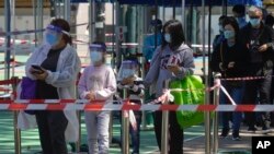 Warga antre dengan mengenakan masker untuk tes COVID-19 di pusat pengujian sementara di Hong Kong, Rabu, 9 Maret 2022. (AP Photo/Vincent Yu)