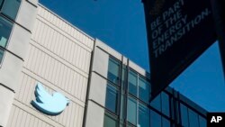 FILE - A Twitter logo hangs outside the company's San Francisco offices on Nov. 1, 2022.
