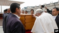 Paus Fransiskus menyentuh peti mati mendiang Paus Emeritus Benediktus XVI setelah misa pemakamannya di Lapangan Santo Petrus di Vatikan, Kamis 5 Januari 2023.