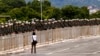 A woman walks in front of military police prepared for an announced protest by supporters of former President Jair Bolsonaro, in Brasilia, Brazil, Jan. 11, 2023. The protests did not take place.