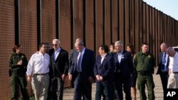 Rais wa Marekani Joe Biden akitembea na maafisa wa mpakani karibu na ukuta unaogawanyisha Marekani na Mexico. Jumapili Januari 8,2023
