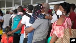 Migrantes haitianos hacen fila para registrarse para un vuelo a Chile, en el Aeropuerto Internacional Toussaint Louverture, en Puerto Príncipe, Haití, el domingo 30 de enero de 2022. Miles de haitianos en los últimos meses han abordado vuelos chárter a América del Sur, según información de seguimiento de vuelos y verificación independiente de The Associated Press en colaboración con la Universidad de California, Berkeley. (Foto AP/Odelyn Joseph)